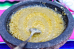 Fresh spiced green salsa for seasoning traditional Mexican food at a street market, prepared from minced jalapenos peppers, select