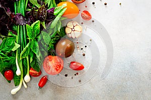 Fresh spinach,green onion, basil, herbs, dill and tomatoes on gray concrete background, selective focus. Top view. Toned