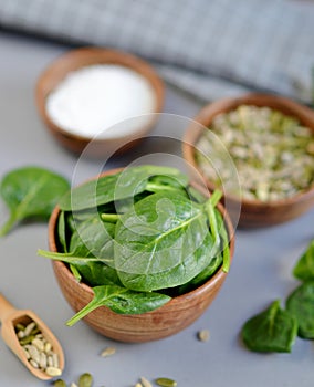 Fresh Spinach Leaves, Sea Salt and Seeds Nuts Mix in Wooden Bowl