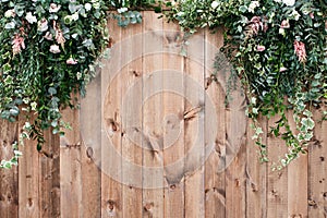 Fresh spring greens with white flower and leaf plant over wood fence background