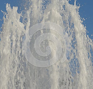Fresh spring pouring water. Fountain on blue sky.