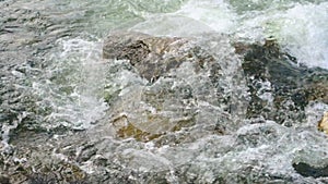 Fresh spring river flowing over rocks on sunny day, slow motion video