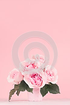 Fresh spring romance roses bouquet in pastel pink color on white wood board, copy space.