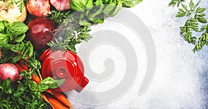 Fresh spring root vegetables and spicy herbs and red pan. Healthy food, cooking concept. Gray table background with copy space.