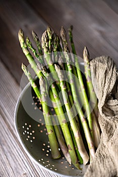 Fresh sprouts of picked asparagus in metal colander