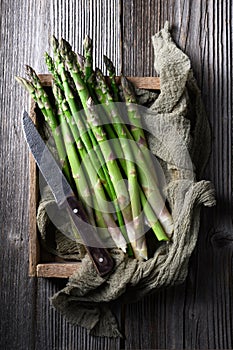 Fresh sprouts of picked asparagus in wooden box
