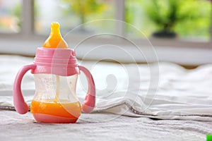 Fresh squeedzed orange juice in baby pink milk bottle