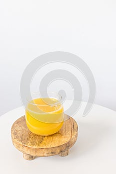 Fresh squeezed orange juice in glass on table on white background. Healthy beverage for breakfast