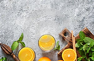 Fresh squeezed orange juice on a gray concrete background with mint