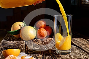 Fresh squeezed orange juice poured into a glass on wooden background.Healthy eating,detox,dieting and vegetarian concept