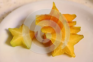 Fresh star fruit sliced, ready to be eaten. Sweet fruit in a white dish