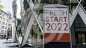 Fresh Start 2022 on a city-center sign in front of a modern office building