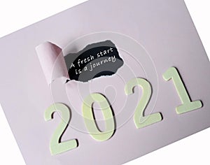 A fresh start is a journey text on torn paper with Year 2021 background