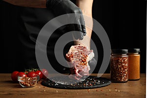 Fresh steak with spices on a dark background, barbecue cooking