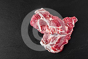 Fresh steaks from Raw pork meat on dark stone background, Top view, food concept