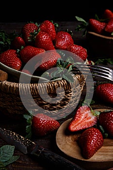 Fresh strawberries in a basket with mint and black background