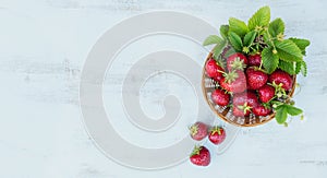 Fresh strawberries in a basket on rustic wooden background top view. Healthy food on white wooden table mockup. Delicious, sweet,