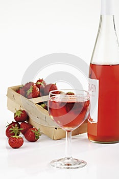 Fresh strawberries in basket and strawberry wine in glass