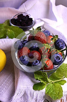 Fresh strawberries and blueberries in a glass bowl.