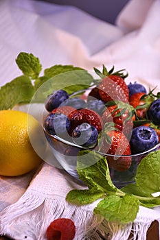 Fresh strawberries and blueberries in a glass bowl.