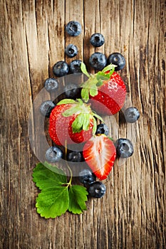 Fresh strawberries and blueberries on wooden background