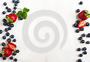 Fresh strawberries and blueberries on wooden background