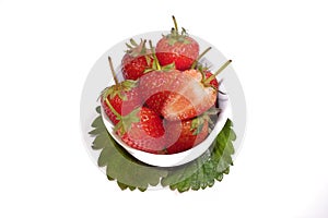 fresh strawberries in bowl on leaf.