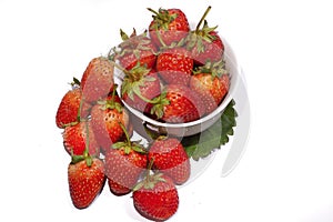 Fresh strawberries in bowl on leaf.