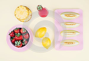 Fresh strawberries in bowl and melone on pastel yellow background.