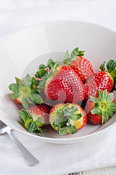 Fresh strawberries in bowl on white