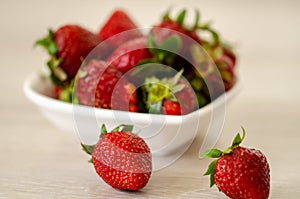 Fresh strawberries in a bowl on wooden table