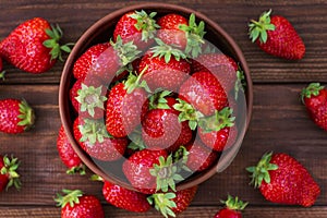 Fresh strawberries in a bowl on wooden table. Strawberry in a Bowl. Top view