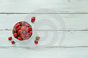 Fresh strawberries on ceramic bowl top view. Healthy food on white wooden table mock up. Delicious, sweet, juicy and