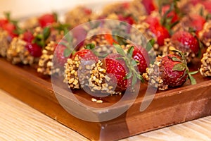 Fresh strawberries covered with dark chocolate and nuts