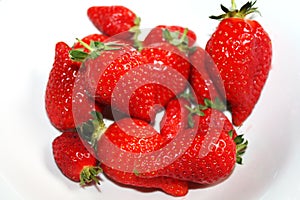 Fresh strawberries isolated on the white plate.