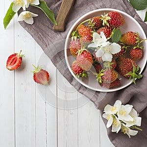 Fresh strawberries and Jasmine flowers on a light background. Summer concept. Copy space