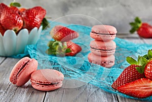 Fresh strawberries and macarons atop a blue tablecloth photo