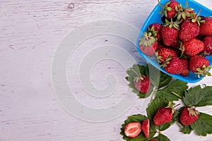 Fresh strawberries in mycelium on a wooden table in blue background