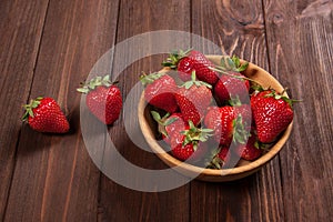 Fresh strawberries on an old wooden surface.