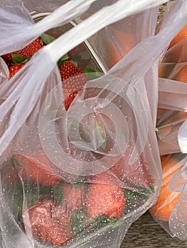 Fresh strawberries in a plastic bags with raindrops on it