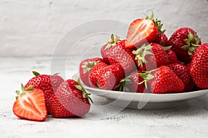 Fresh strawberries in plate on marble white table. Fresh nice strawberries. Strawberry field on fruit farm. Heap of Red strewberry