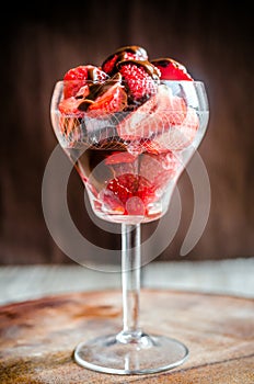 Fresh strawberries under chocolate topping in the glass