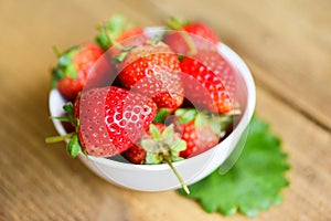 Fresh strawberries on white bowl on the table, Red ripe strawberry on wooden background