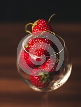 Fresh strawberries in wine glass on table. Ripe strawberry closeup. Sweet summer harvest. Juicy dessert. Healthy food. Red berries