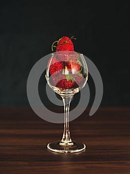 Fresh strawberries in wine glass on table. Ripe strawberry closeup. Sweet summer harvest. Juicy dessert. Healthy food. Red berries