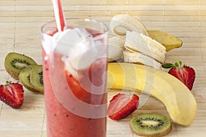 Fresh strawberry-banana smoothie with the addition of kiwi in a glass