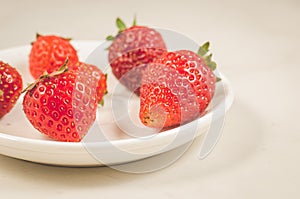 fresh strawberry berries in a bowl/fresh strawberry berries in a bowl on a white table closeup. Selective focus