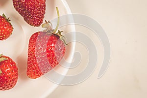 Fresh strawberry berries in a white bowl/fresh strawberry berries in a bowl on a white background. Top view and copy space