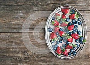 Fresh strawberry and blueberry mix on a metal dish (tray) over a