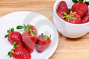 Fresh strawberry in cup on wooden
